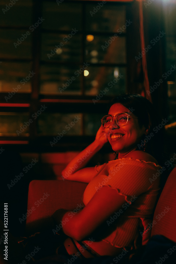 Woman in red light, smiling to the camera Woman in red light, smiling to the camera