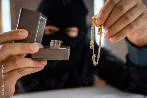 Valokuva Thief holding jewelry indoor. Robbery concept.