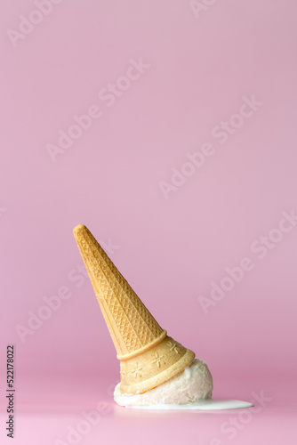 Dropped ice cream cone on a pink background photo