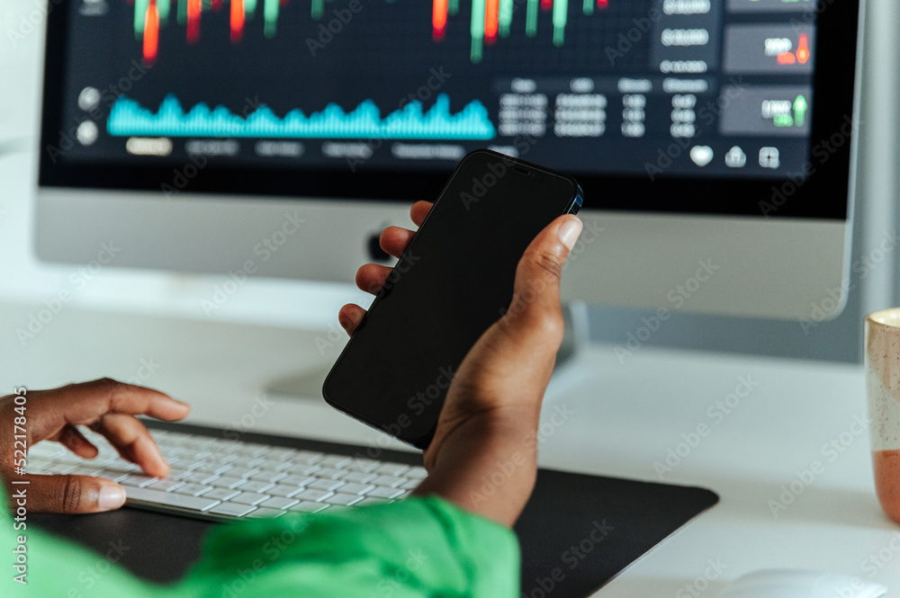 © David Prado/Stocksy - Crop woman using smartphone in office © David Prado/Stocksy - Crop woman using smartphone in office