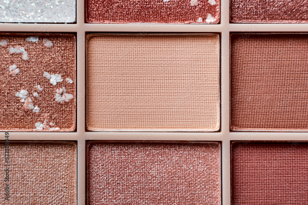 Fototapeta premium Eyeshadow colorful shades palette in beige tones close-up. Beauty abstract background.