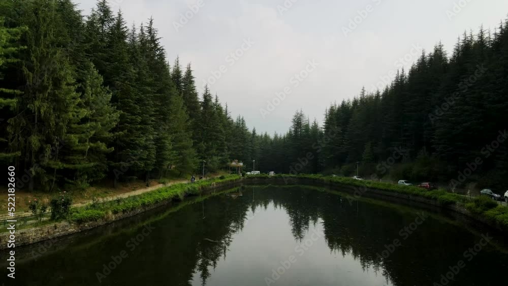 Beautiful landscape in aerial drone shot. Forest woods and calm tranquil lake. Fat white clouds mirroring on water surface. Beautiful landscape in aerial drone shot. Forest woods and calm tranquil lake. Fat white clouds mirroring on water surface.