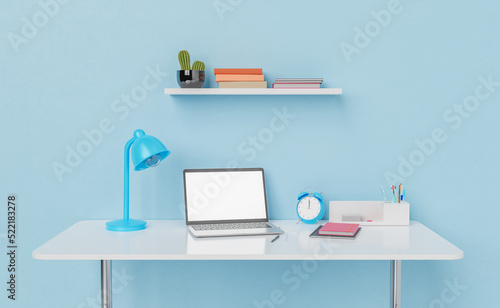 Laptop on working table with lamp and alarm clock