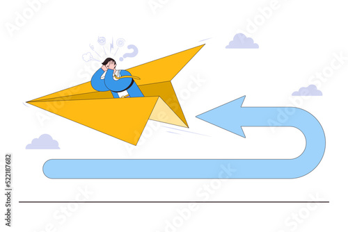 Business turning point, financial trend change, and break event concepts. Frustrated businessman investor fly using paper airplane at his reverse direction pathway with direction arrow backward