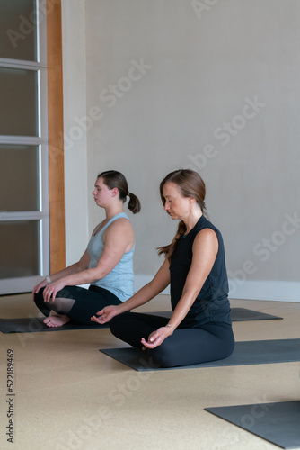 two women doing yoga in modern studio