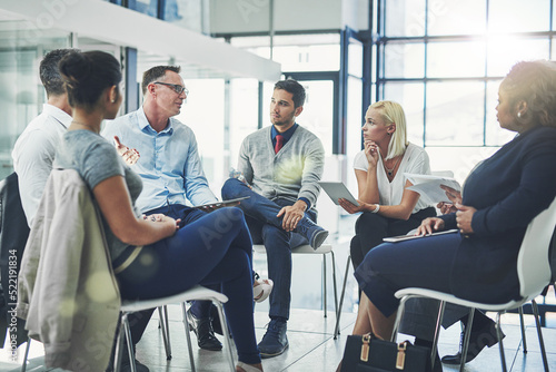 Modern business people in an informal team building discussion or business talking session. Team leader, manager or supervisor talking to a group of employees or colleagues on new workflow management photo