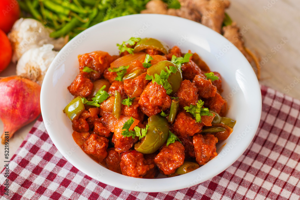selective focus of Soya Manchurian/Chili Soya bean chunks recipe. with a decorative background.