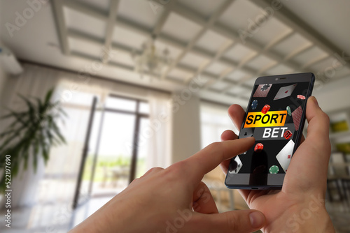 Tela Hand hold a phone with betting online on a screen