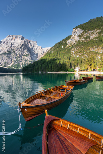 Amazing Sunrise view of Lago di Braies (Pragser Wildsee) with Wooden boats, one of the most beautiful lake in South Tirol, Dolomites mountains, Italy. Popular tourist attraction.
