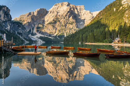 Fototapeta Naklejka Na Ścianę i Meble -  Amazing Sunrise view of Lago di Braies (Pragser Wildsee) with Wooden boats, one of the most beautiful lake in South Tirol, Dolomites mountains, Italy. Popular tourist attraction.