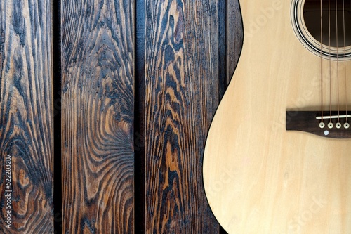 Obraz na plátně Acoustic guitar resting against a wall background