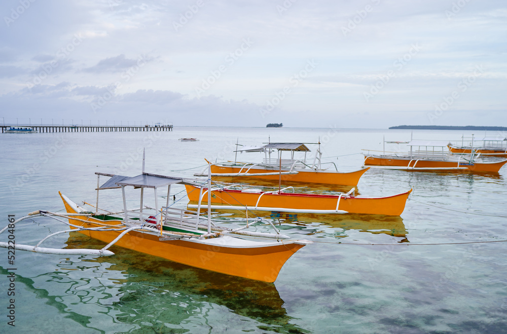 Obraz premium Beautiful tropical landscape with traditional wooden fishing boats on the sea shore.