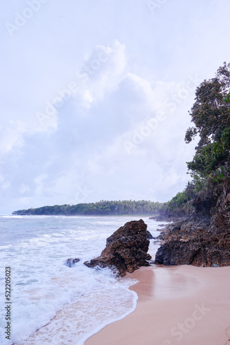 Beautiful tropiical landscape. Beach with sand, rocks and blue cloudy sky. photo