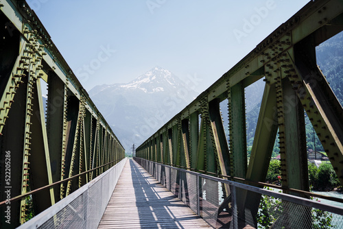 Hiking on the Swiss Alp Mountains. Metal girder bridge with pathway.