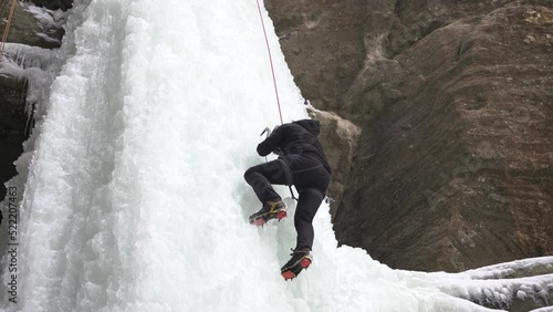 A climber climbing up a frozen waterfall in the Wildcat Canyon of Starved Rock State Park. photo