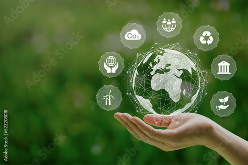 ESG icon concept in the woman hand for environmental, social, and governance by using technology of renewable resources to reduce pollution and carbon emission.