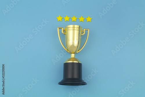 Gold champion trophy cup with five stars on blue background.