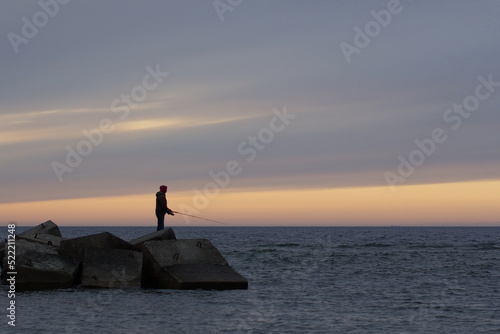 silhouette of a fishman on the beach