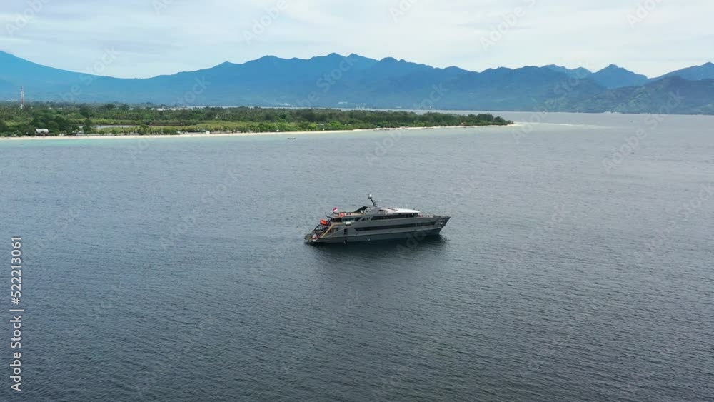 aerial of luxury mega yacht anchored in bay of Gili Islands with Lombok in background in Indonesia aerial of luxury mega yacht anchored in bay of Gili Islands with Lombok in background in Indonesia