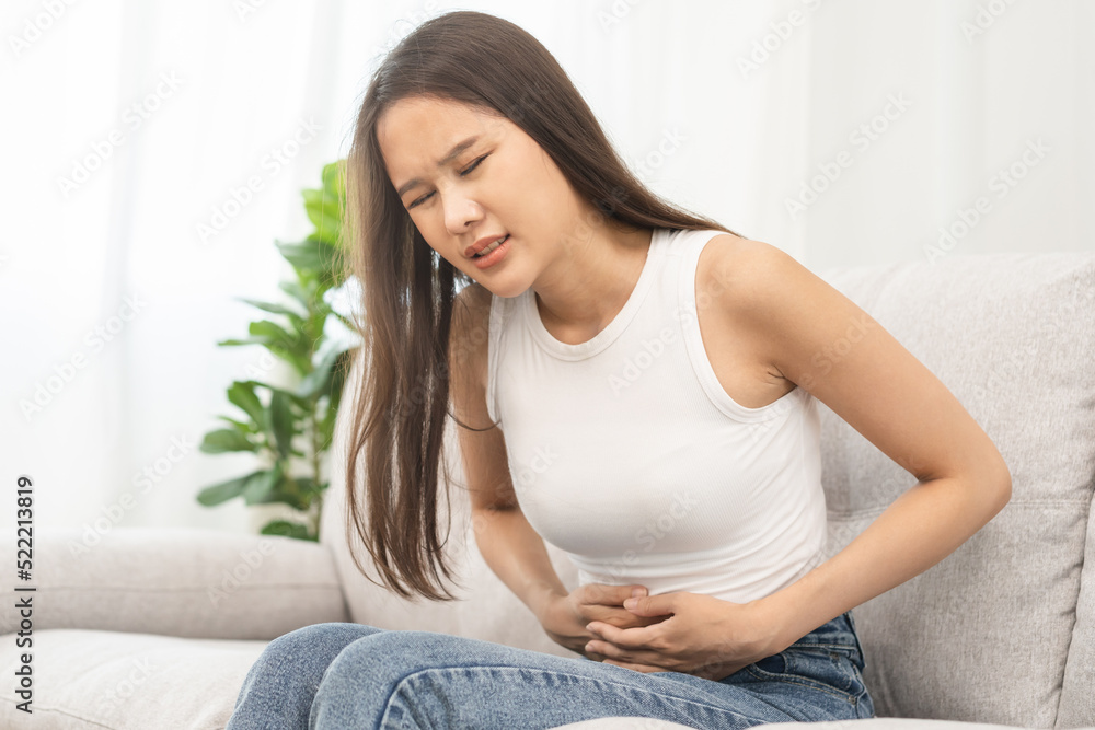 Flatulence asian young woman, girl hand in stomach ache, suffer from food poisoning, abdominal pain and colon problem, gastritis or diarrhoea. Patient belly, abdomen or inflammation, concept.