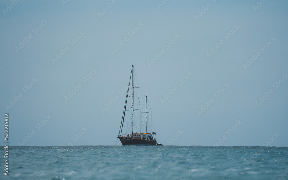 Old school ship in the ocean, blue cloudless sky. Old school ship in the ocean, blue cloudless sky.