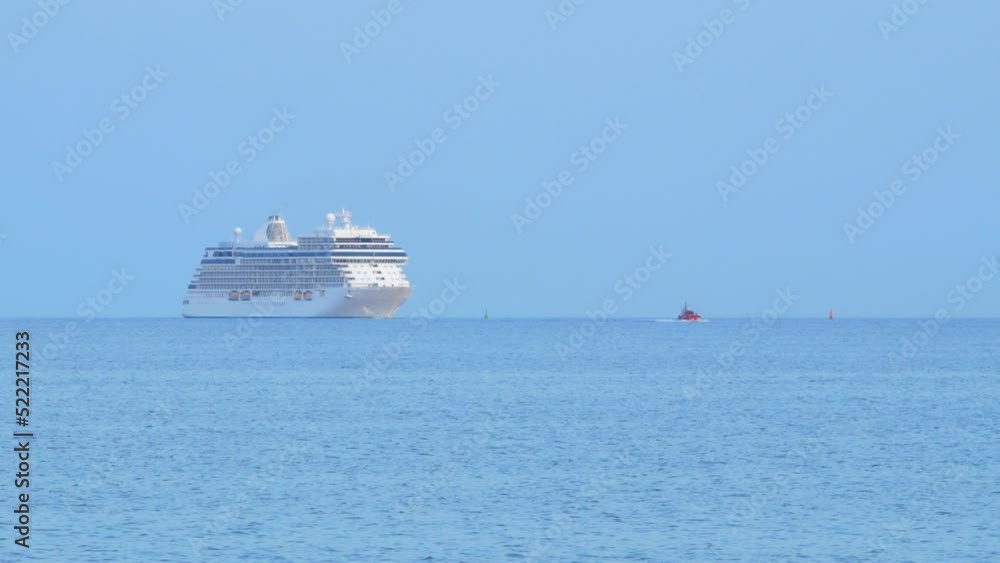 Large white cruise liner Seven Seas Splendor arriving at the port of Liepaja (Latvia), early morning golden hour, water transportation, Baltic sea, vacation, distant medium shot with thug boat Large white cruise liner Seven Seas Splendor arriving at the port of Liepaja (Latvia), early morning golden hour, water transportation, Baltic sea, vacation, distant medium shot with thug boat
