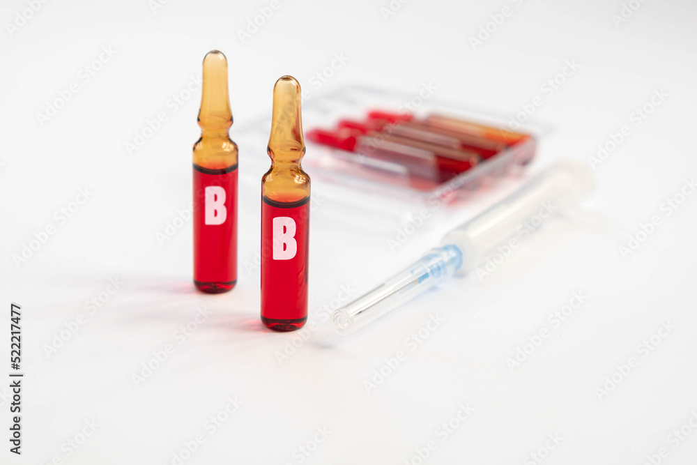 Injection of vitamins B. Ampoules with red liquid. Copy space Injection of vitamins B. Ampoules with red liquid. Copy space