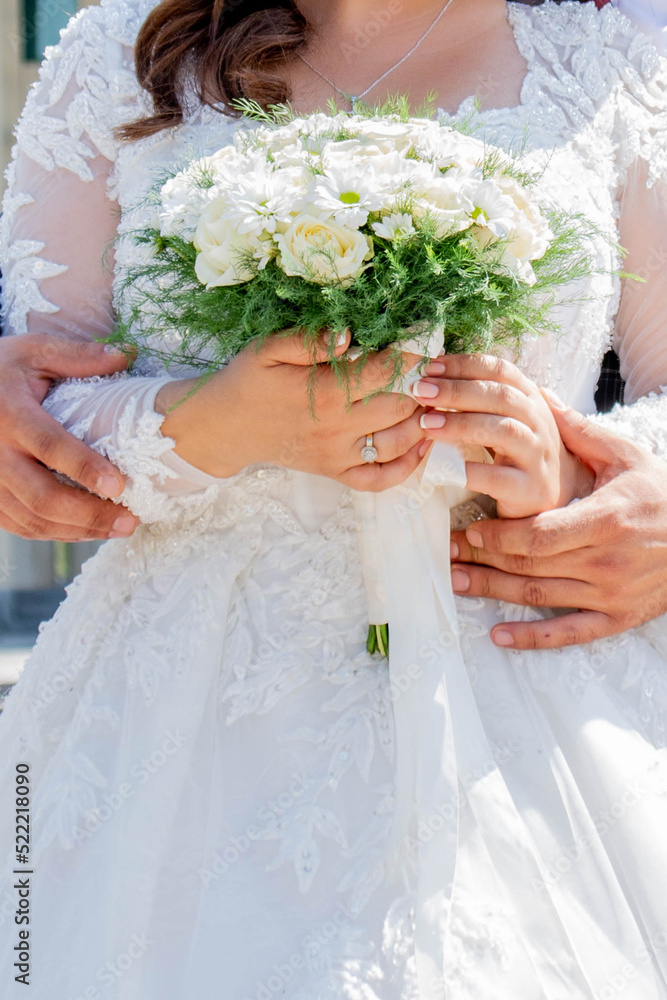 Wedding bouquet in the hands of the bride. White dress of the bride and a bouquet of flowers Wedding bouquet in the hands of the bride. White dress of the bride and a bouquet of flowers
