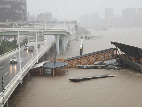 Brisbane, Australia - February 27, 2022: Wild weather and heavy rain falls from Tropical Cyclone storm Brisbane Central Business District. The North Quay ferry terminal is flooded and closed.