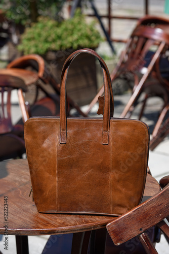 close-up photo of brown leather bag on a wooden table