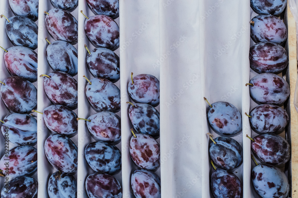 Ταπετσαρία Ripe prunes, fresh fruits arranged in rows in a box on white paper