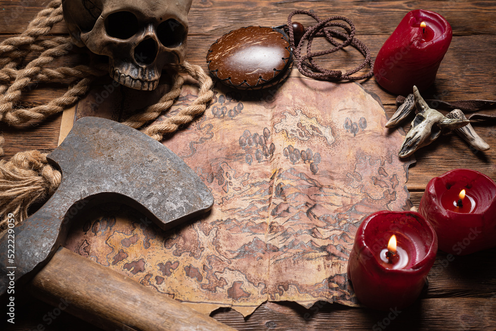 Fotografie Ancient map, battle axe and burning candles on the top view table background