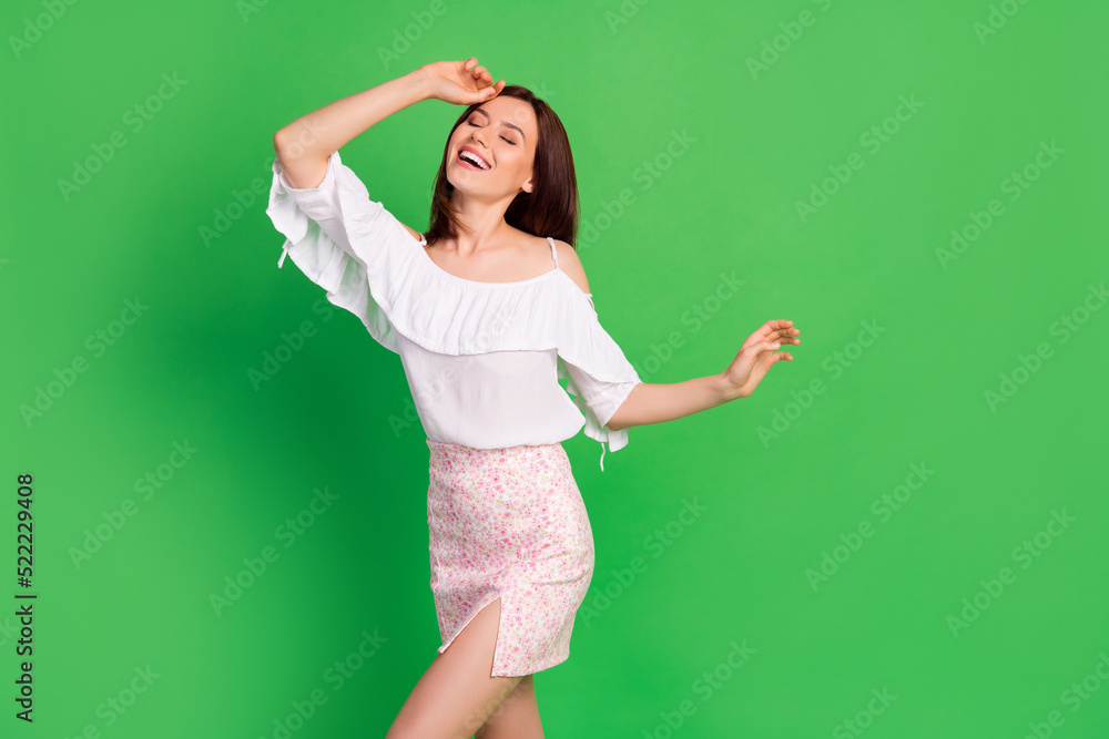 Photo of positive cheerful girl trendy short outfit bright smile arm touch head flirty boyfriend isolated on green color background Photo of positive cheerful girl trendy short outfit bright smile arm touch head flirty boyfriend isolated on green color background