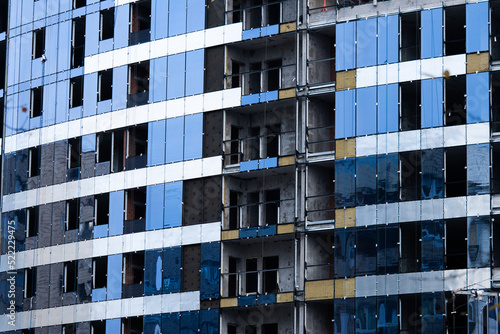 Facing the building with a ventilated facade. Aluminum colored facades. Modern facades of high-rise buildings. Construction of a large residential complex