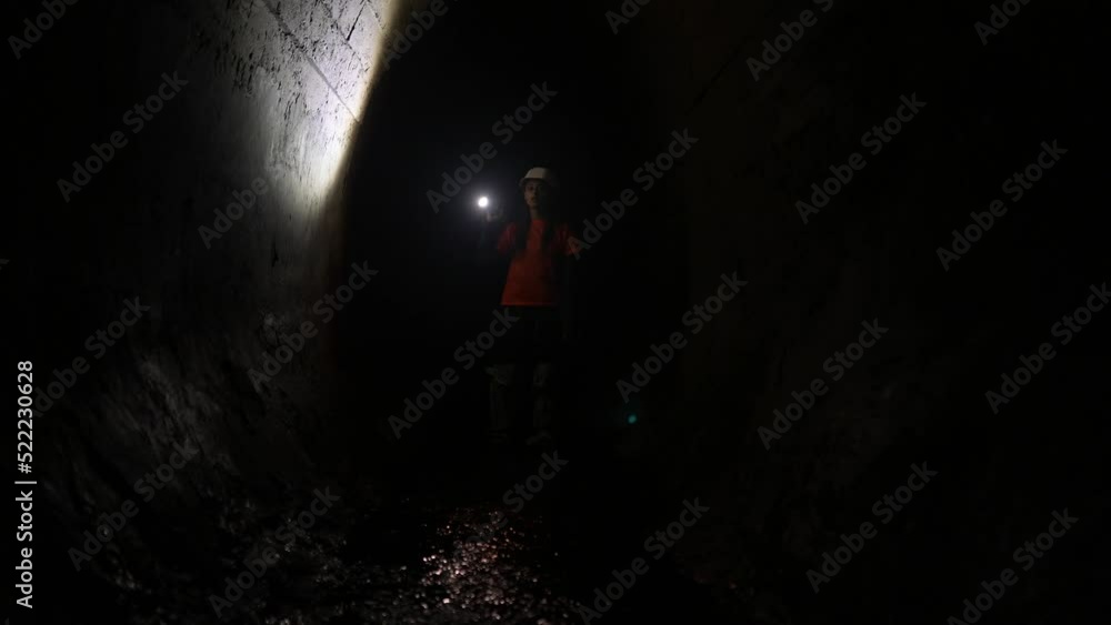 Female digger with flashlight explores the tunnel Female digger with flashlight explores the tunnel