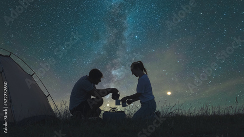 The two travelers preparing tea at the campsite on a starrying sky background