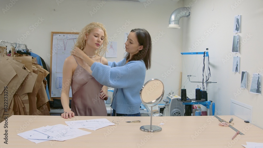 Obraz premium 4K. The client tries on a ready - made dress, which was sewn by a seamstress
