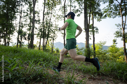 Woman trail runner running at tropical forest mountain peak © lzf
