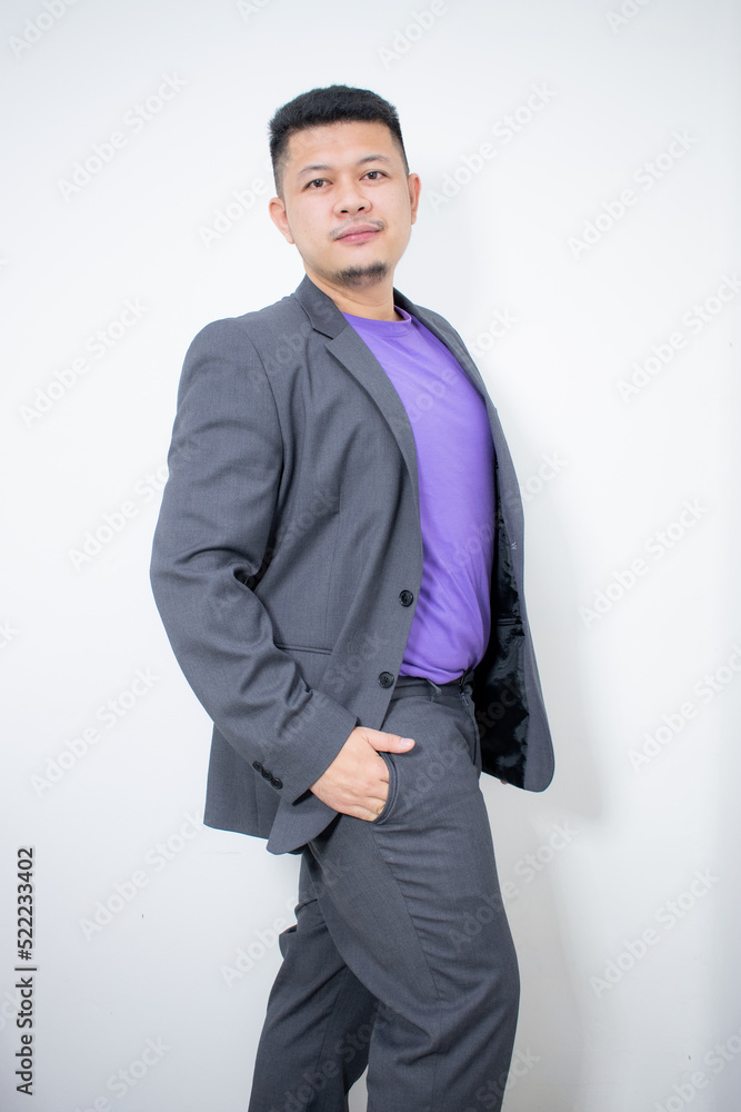 © Igunt - Modelling snapshots. Serious narcissistic self-confident attractive handsome man in classic suit holds hands on belt posing isolated in white studio background. Fashion offer. Copy space for ad