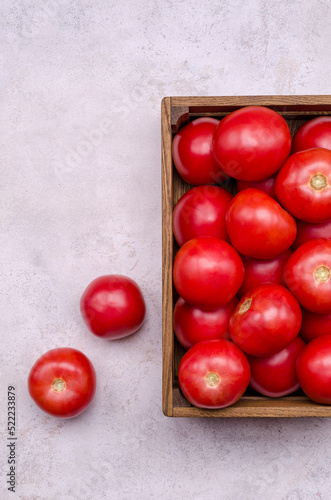 Large raw red tomatoes in a wooden box