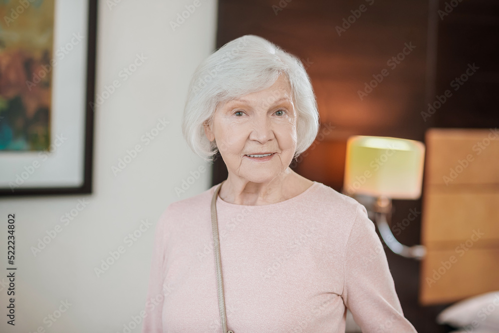 Short-haired elegant senior lady in a hotel room