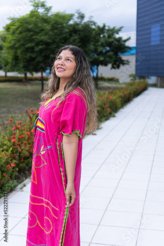 woman walking in traditional clothing in a city park.