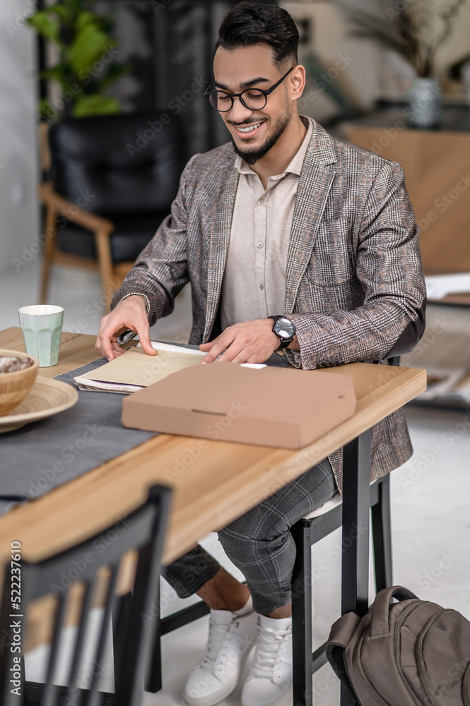 Elegant man sitting at table looking at correspondence Elegant man sitting at table looking at correspondence