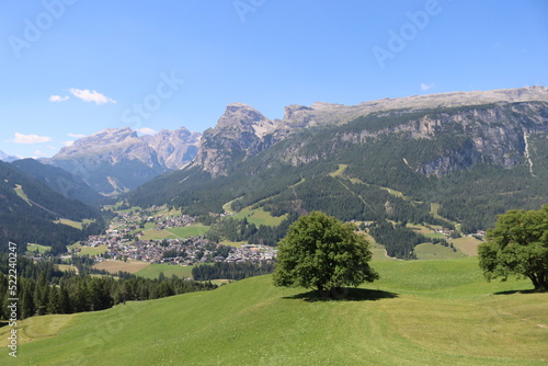 Coravara  Italy-July 16  2022  The italian Dolomites behind the small village of Corvara in summer days with beaitiful blue sky in the background. Green nature in the middle of the rocks.