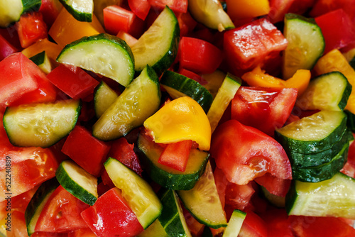 Juicy salad of seasonal summer vegetables close-up. Tomatoes, cucumbers, bell peppers.