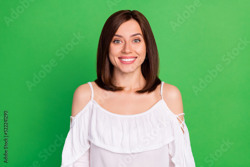 Photo portrait of lovely gentle elegant young woman look camera toothy smiling wear stylish white look isolated on green color background