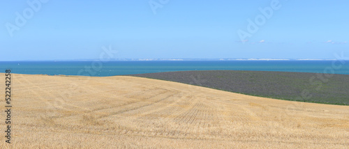 The white cliffs of Dover as seen from harvested agricultural fields along the French opal coast in the village Escalles in the department Pas-de-Calais on a sunny summer day