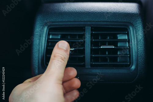 Man adjusting air conditioner inside the car.