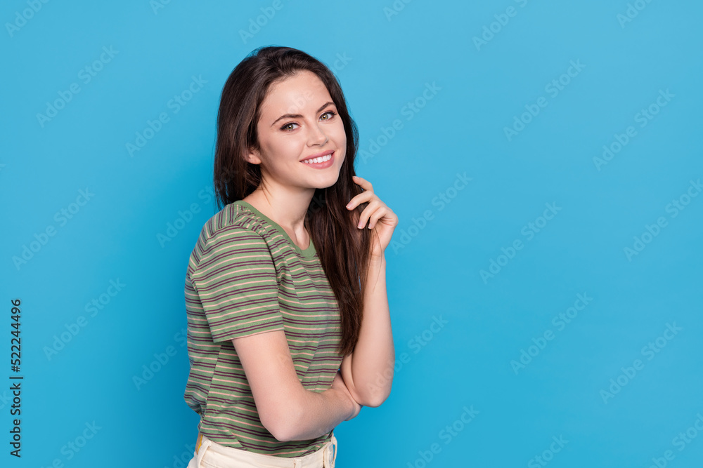 Photo of sweet young brunette lady touch hair wear green t-shirt isolated on blue background Photo of sweet young brunette lady touch hair wear green t-shirt isolated on blue background