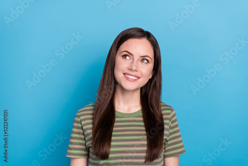 Photo of impressed young brunette lady look up wear green t-shirt isolated on blue color background © deagreez